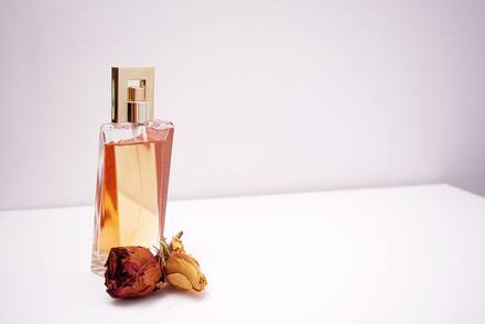 A glass perfume bottle with dried flowers